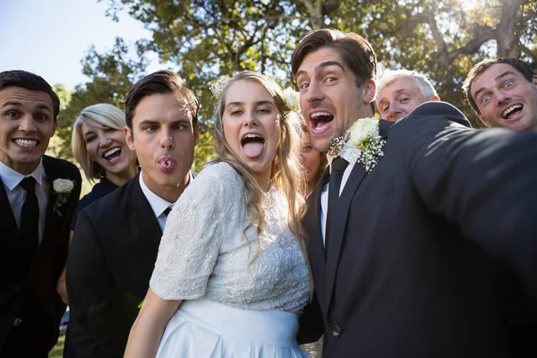Par poserar med gäster under bröllop — Stockfoto