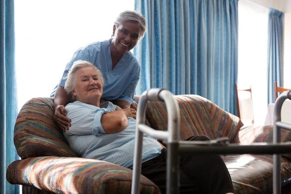 Lachende verpleegkundige met senior vrouw — Stockfoto