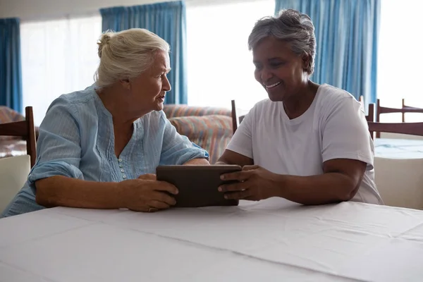 Mujer mayor mostrando tableta a amigo —  Fotos de Stock