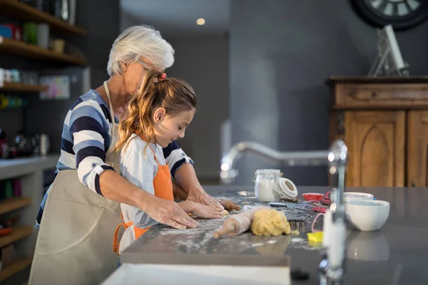 Mormor hjälper barnbarn att platta deg — Stockfoto