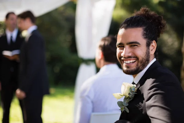 Schöner Bräutigam lächelt im Park — Stockfoto