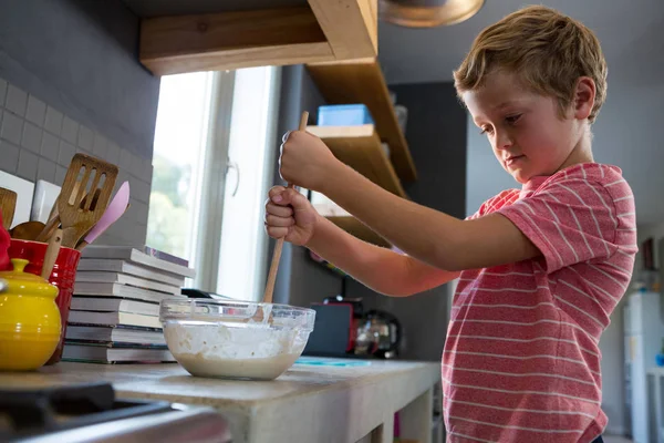 Jongen mengen slagman in keuken — Stockfoto