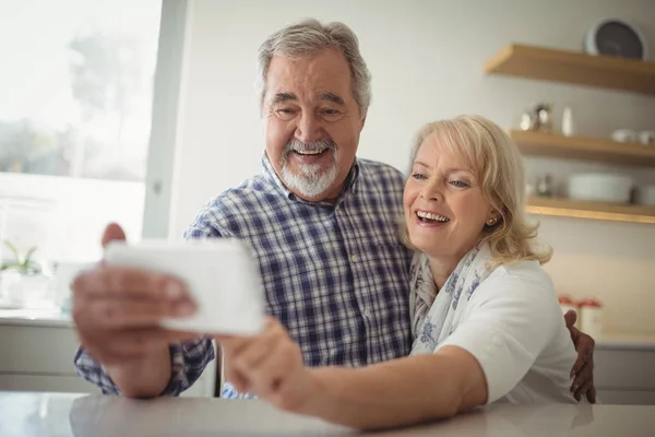 Pareja mayor tomando una selfie en la cocina — Foto de Stock