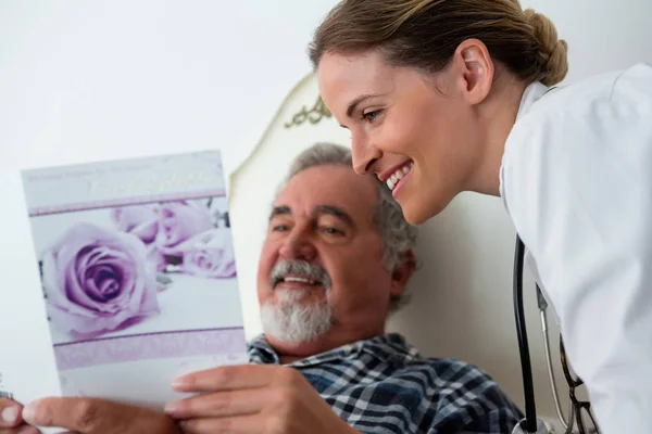 Doctor mostrando obtener tarjeta de bienestar para el paciente — Foto de Stock