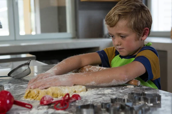 Мальчик печет тесто на кухне — стоковое фото