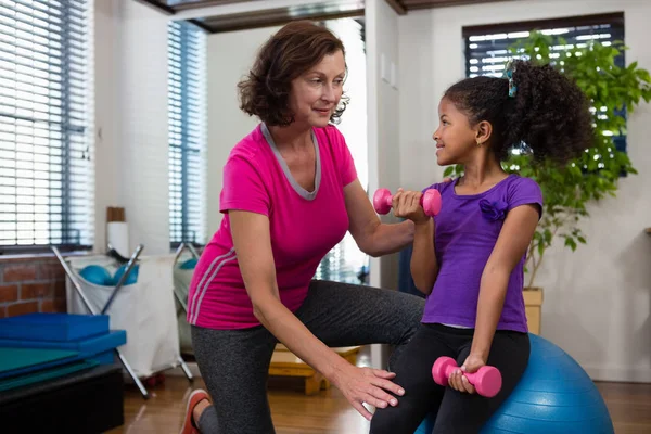 Fisioterapeuta femenina ayudando a paciente niña — Foto de Stock