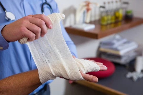 Fysiotherapeut bandage zetten gewonde hand — Stockfoto