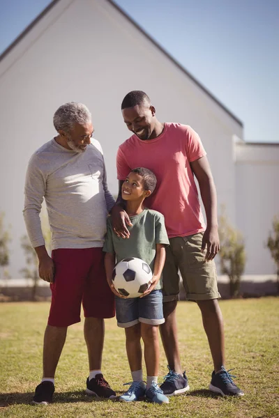 Сім'я, що стоїть в саду з футболом — стокове фото