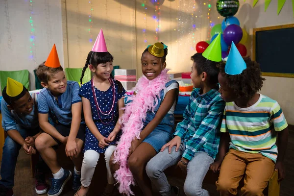 Glückliche Kinder sitzen gegen Wand — Stockfoto