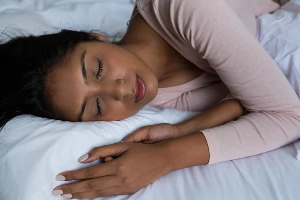 Jovem mulher dormindo na cama — Fotografia de Stock