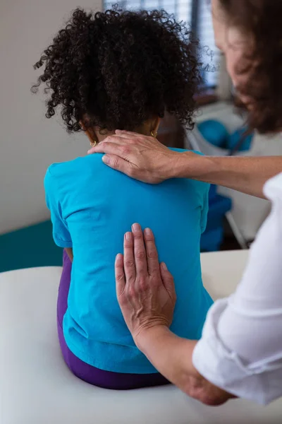 Physiotherapeutin gibt Mädchen Rückenmassage — Stockfoto