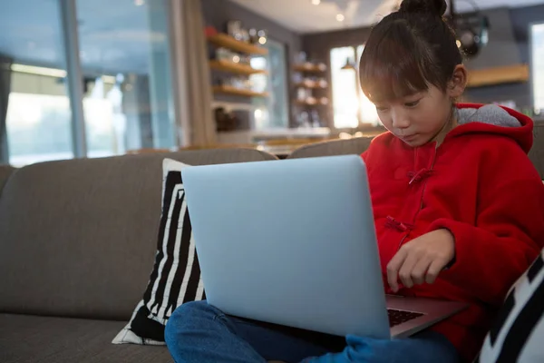 Розслаблена дівчина використовує ноутбук на дивані — стокове фото