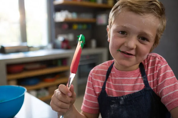 Boy holding spatula with batter — Stock Photo, Image