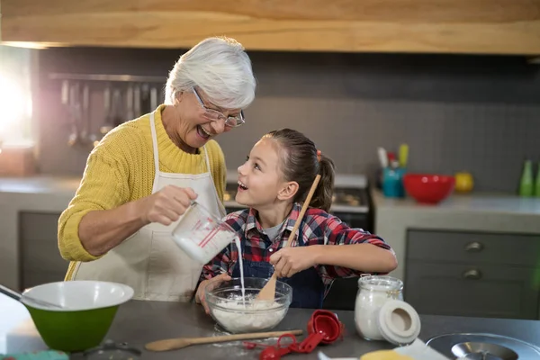 Grandmother and granddaughter is mixing flour — Stock Photo, Image