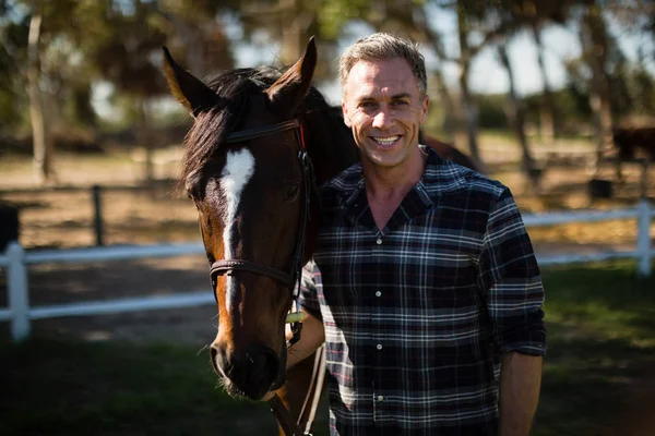 Homme debout avec cheval dans un ranch — Photo