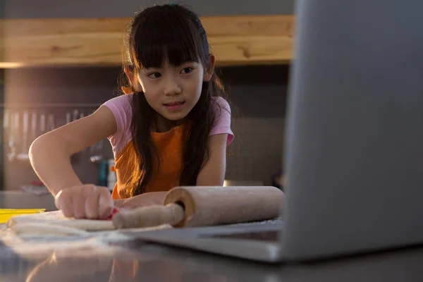 Flickan tittar in laptop i köket — Stockfoto