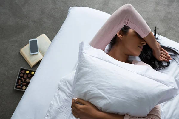 Mujer acostada en la cama sobre el suelo —  Fotos de Stock