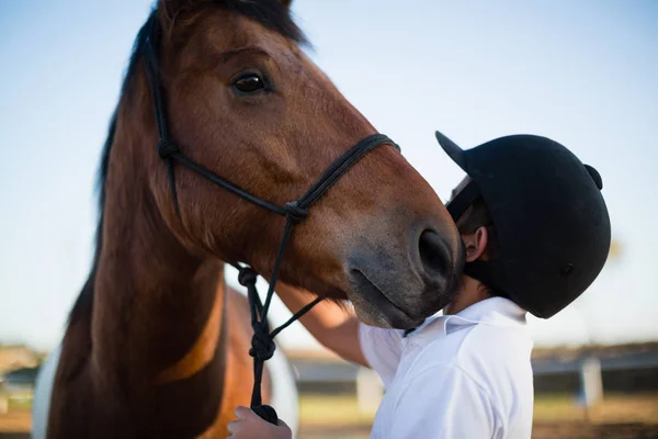 Cavalier garçon caressant un cheval — Photo