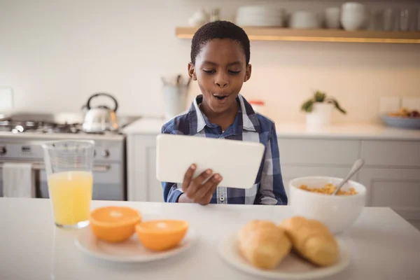 Pojke med digital tablett i kök — Stockfoto