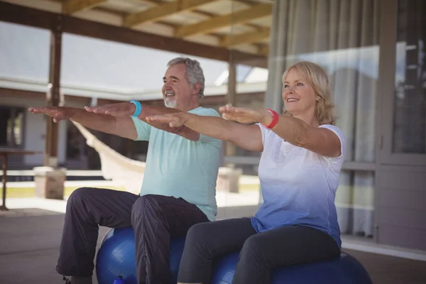 Pareja mayor haciendo ejercicio sobre pelota de ejercicio — Foto de Stock