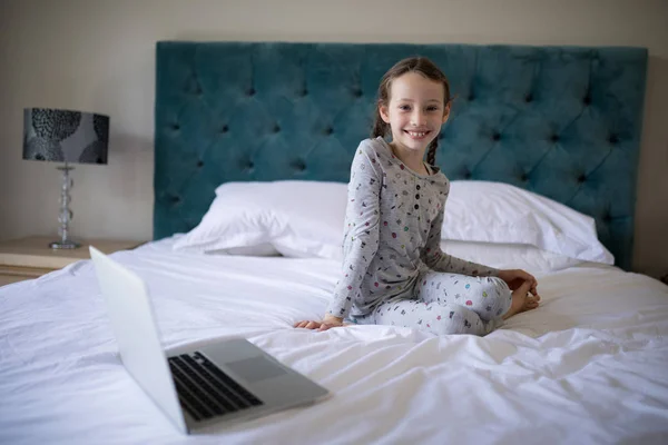 Souriante fille assise sur le lit dans la chambre — Photo