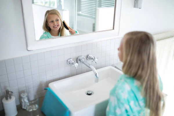 Mädchen kämmt ihr Haar im Badezimmer — Stockfoto