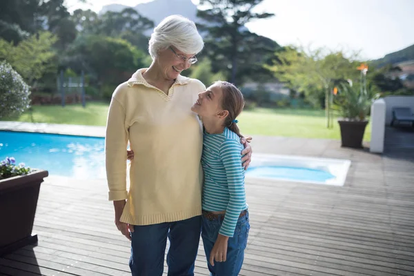 Nieta y abuela abrazando cerca de la piscina —  Fotos de Stock