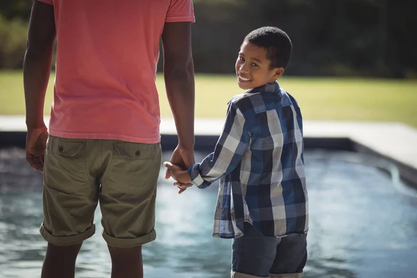 Padre e figlio in piedi vicino alla piscina — Foto Stock