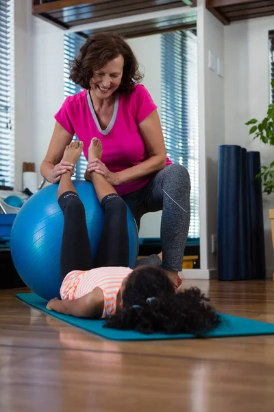 Fisioterapeuta ayudar a niña paciente en el estiramiento — Foto de Stock