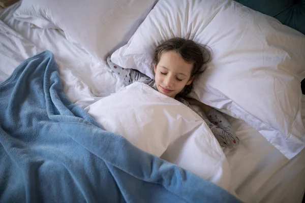 Девушка спит на кровати в спальне — стоковое фото