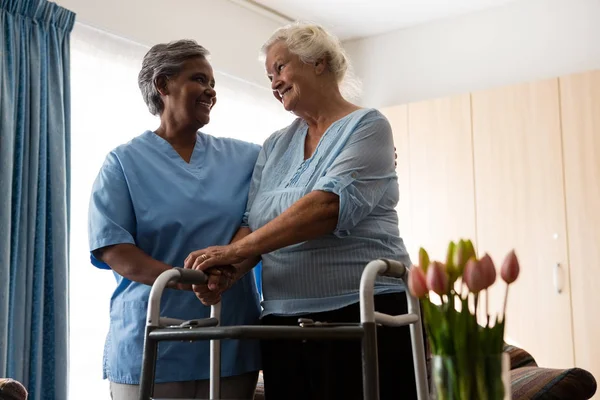 Verpleegkundige meewerkende senior patiënt in wandelen — Stockfoto