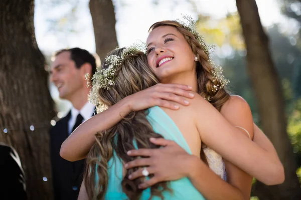 Невеста обнимает свою подругу в парке — стоковое фото