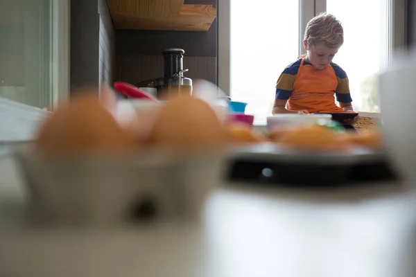 Boy pomocí tabletu na kuchyňské lince — Stock fotografie