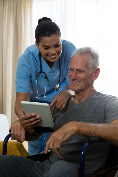 Homem sênior mostrando tablet ao médico — Fotografia de Stock