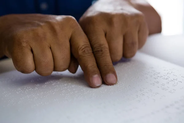 Finger auf älteren Mann, der Brailleschrift liest — Stockfoto