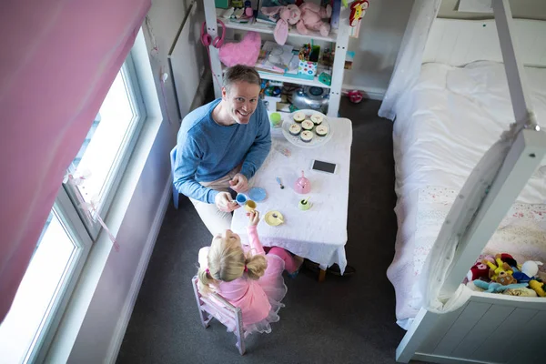 Vater und Mädchen stoßen auf ihre Teetassen an — Stockfoto