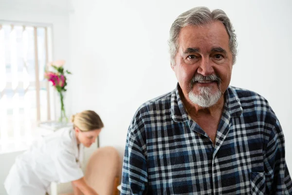 Senior man with female doctor in background — Stock Photo, Image