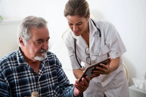 Vrouwelijke arts weergegeven: tablet aan senior man — Stockfoto