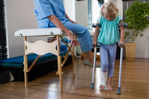 Sjukgymnast hjälpa flickan patienten att gå — Stockfoto