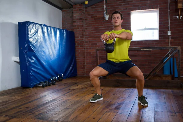 Entschlossener Mann trainiert mit Kettlebell — Stockfoto