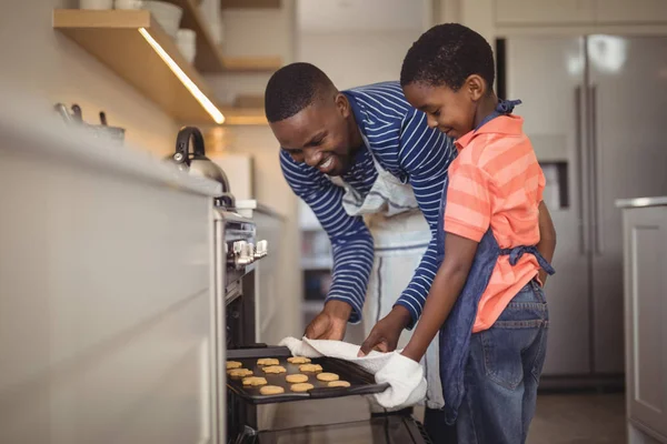 Padre sacando bandeja de galletas frescas — Foto de Stock