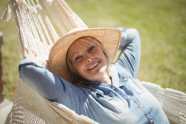 Usměvavá starší žena relaxaci v houpací síti — Stock fotografie