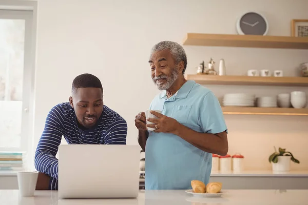 Ojciec i syn za pomocą laptopa, picie kawy — Zdjęcie stockowe