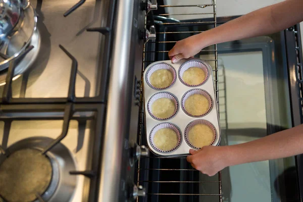 Cropped hands of boy holding muffin tin — Stock Photo, Image
