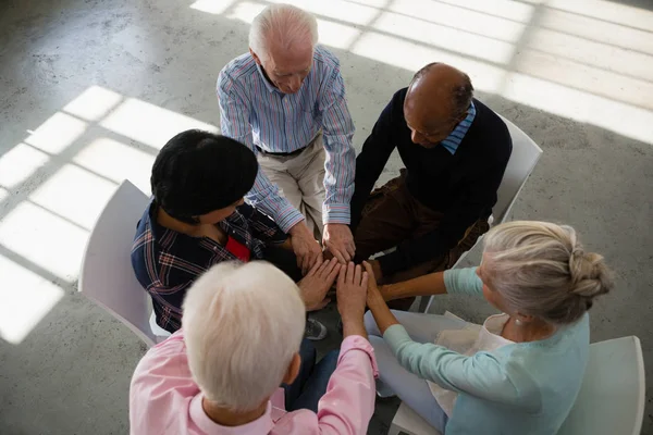 Amis seniors empilant les mains — Photo