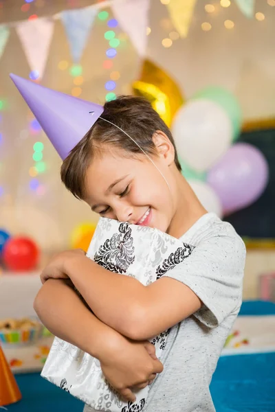 Niño abrazando caja de regalo — Foto de Stock