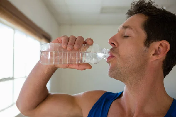 Athlète masculin boire de l'eau dans la salle de gym — Photo