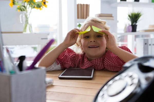 Speels meisje zit met sticky notes — Stockfoto