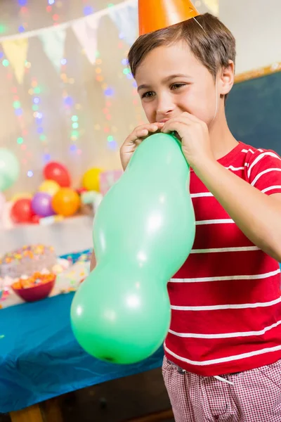 Carino ragazzo soffiaggio palloncino — Foto Stock