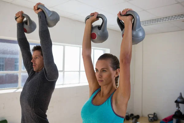 Treinador masculino com atleta levantando kettlebells — Fotografia de Stock